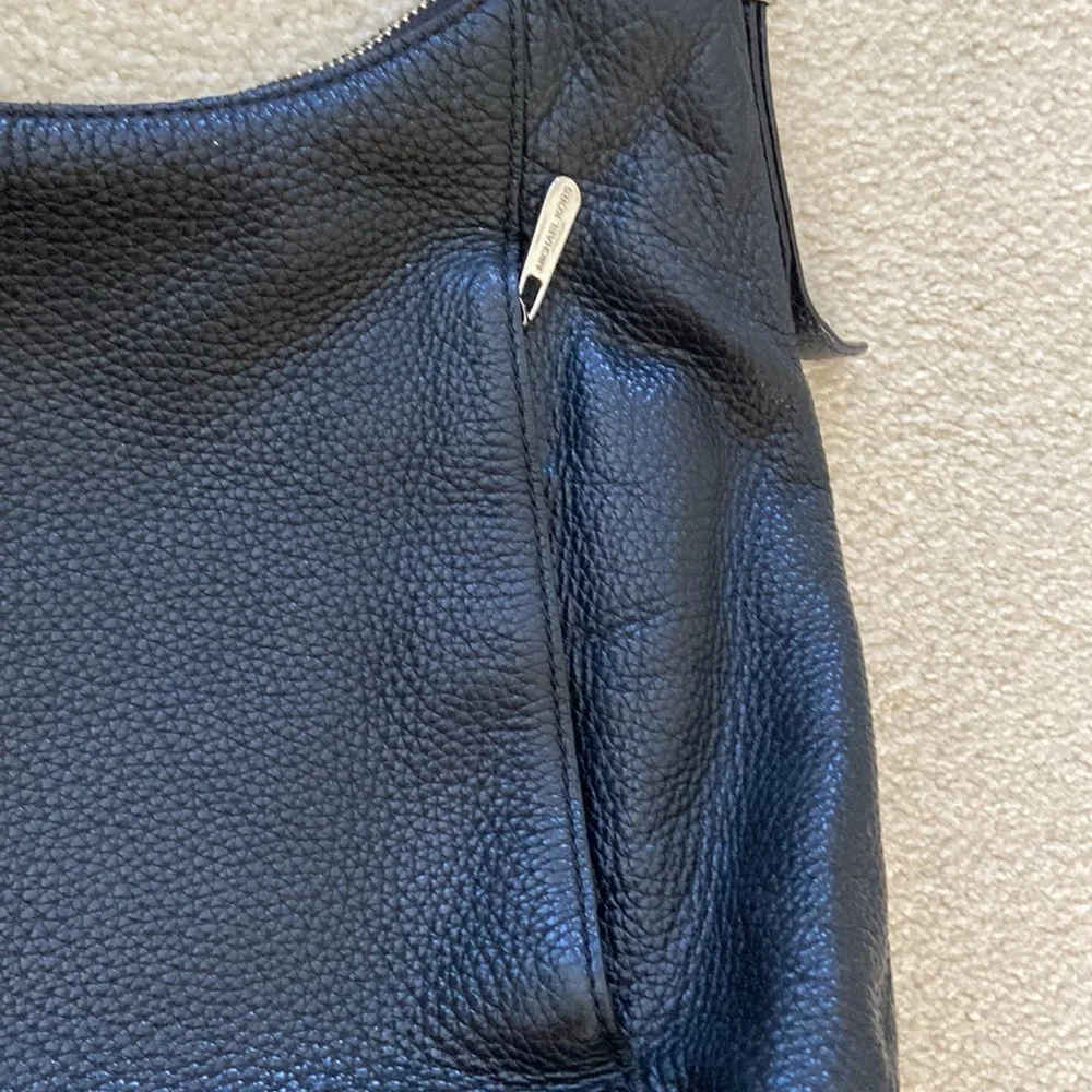 Michael Kors black leather shoulder bag, silver hardware logo on zipper, clean